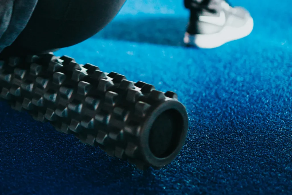 Close-up of a textured foam roller on a blue gym floor