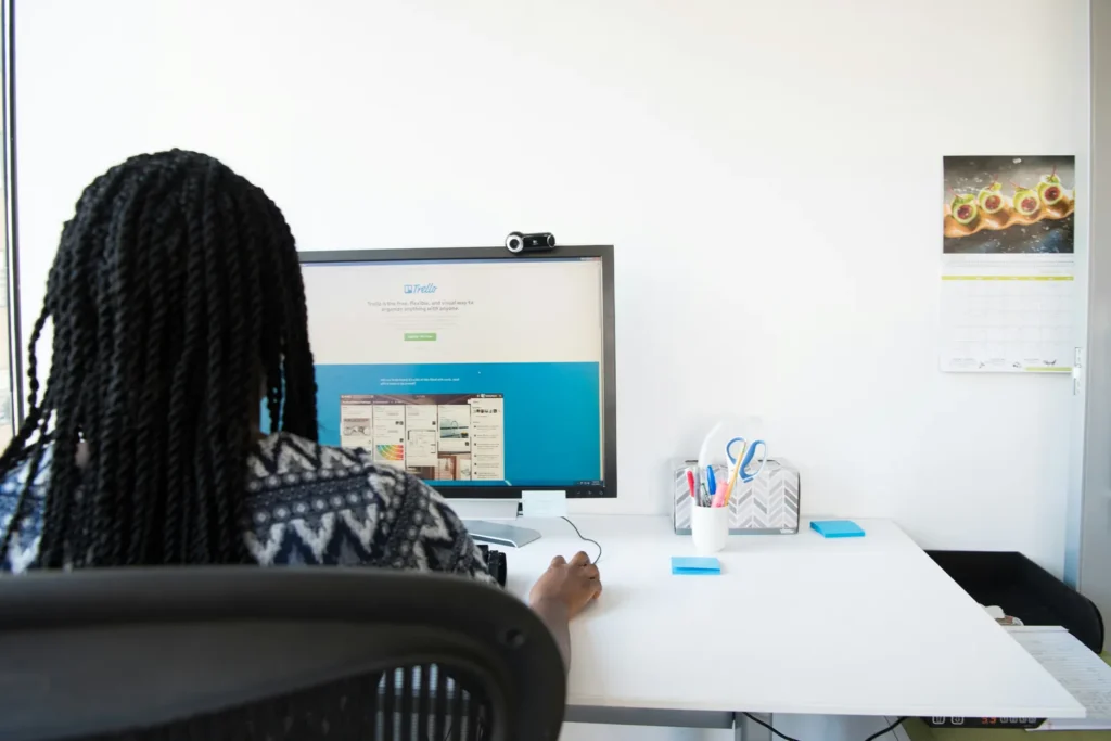 Woman seen from behind looking at a website on a desktop computer