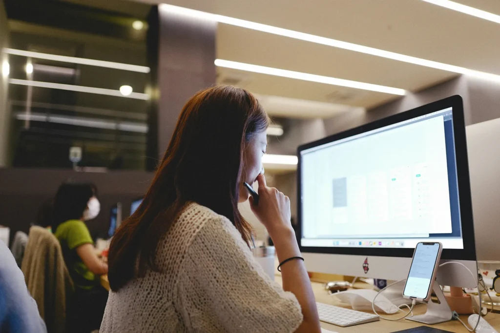 Woman talking on the phone while looking at a computer screen